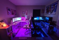 a room with two computer screens and purple lighting in the corner, along with stuffed animals