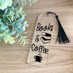 a book and coffee keychain sitting on top of a table next to a plant