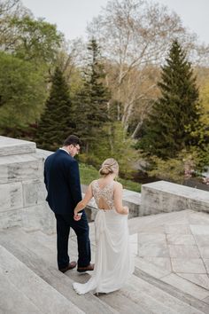 a bride and groom walking up some steps