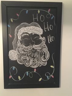 a chalk drawing of santa claus on a blackboard with christmas lights around him and the words ho ho ho