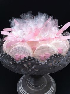 a cake with pink and white decorations in a glass bowl