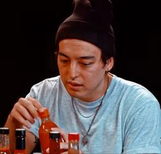 a man sitting at a table with some ketchup bottles