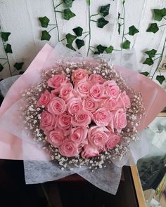 a bouquet of pink roses on top of a table