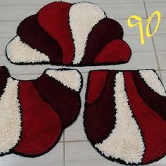 four red and white rugs sitting on top of a tile floor next to each other