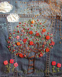 the back side of a pair of jeans with embroidered flowers on them and an image of a tree