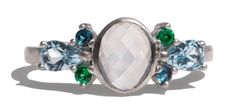 a white ring with green and blue stones