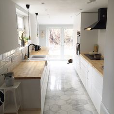 an instagram photo of a kitchen with white cabinets and wood counter tops on twitter