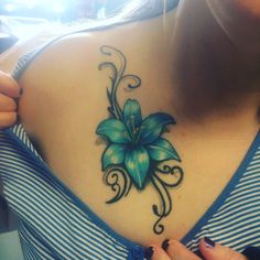 a woman with a blue flower tattoo on her chest