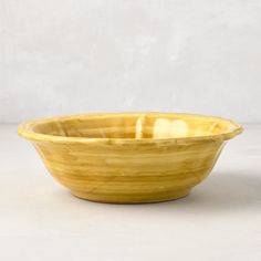 a yellow bowl sitting on top of a white table