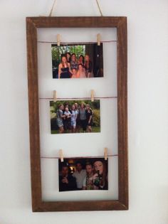 three pictures hanging on clothes pins in front of a white wall with two wooden frames