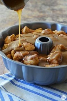 a pan filled with some kind of food and sauce being poured on top of it