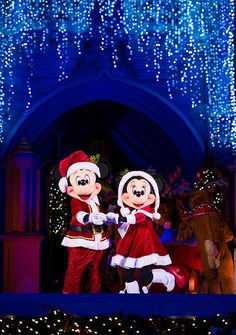 mickey and minnie dancing in front of christmas lights