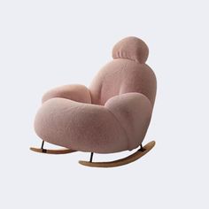 a pink rocking chair with a teddy bear on it's back and footrests