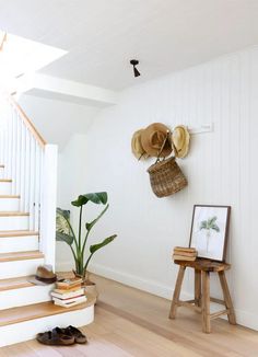 there is a hat rack on the wall next to a chair and a potted plant