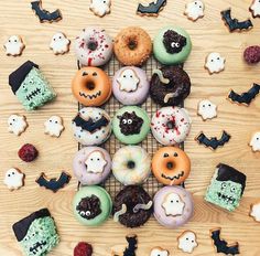 a bunch of doughnuts that are sitting on a wire rack with fake faces