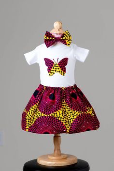 Ankara Baby set comes with a skirt, designed onesie and a headband. It is designed for the little adorable babies to also have a style of culture. These onesies can be gifts for baby showers or even gifts for baby pictures.There is a matching skirt for mums that can be purchase to go with it.  Sizes are from Newborn - 5t Personalized Baby Girl Clothes, Baby African Clothes, African Kids Clothes, Ankara Styles For Kids, Gift Clothes, Girl Clothes Baby, African Babies, African Dresses For Kids