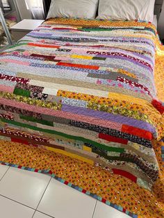 a bed with a colorful quilt on top of it