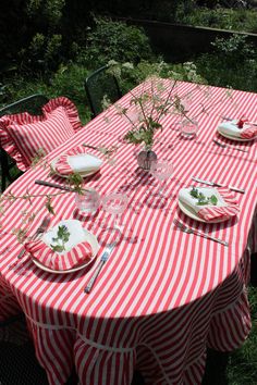 the table is set with red and white striped cloths, silverware, and flowers