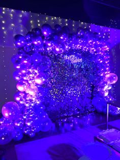 purple and silver balloons are on display in front of a backdrop