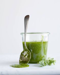 a spoon with some green food in it