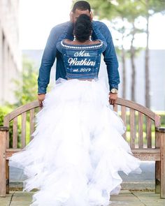 a man and woman sitting on a bench in front of each other with their back to the camera