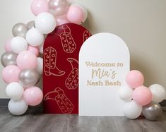 there is a welcome sign and balloons in front of the entrance to a restaurant that has been decorated with pink, silver and white balloons