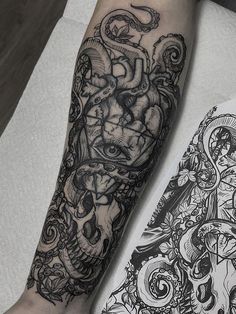 a man's arm with tattoos on it and an image of a demon in the background