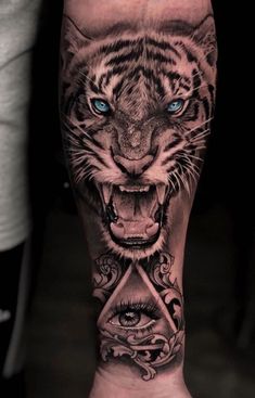 a man's leg with a tiger and an eye on it