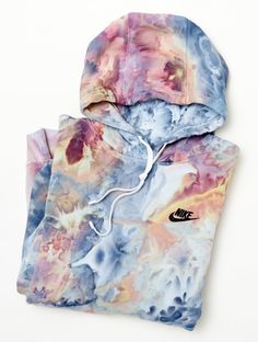 a tie dye hoodie with the nike logo on it, sitting against a white background