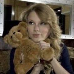 a woman holding a brown teddy bear in her hands