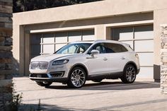 a white suv parked in front of a garage