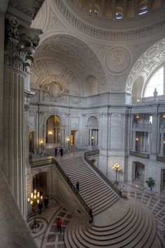 the interior of a large building with stairs and chandeliers on either side of it