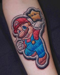 a cartoon character tattoo on the left arm and leg, with a hammer in his hand