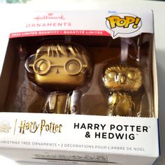 two gold harry potter and hedwig figurines are in the box together