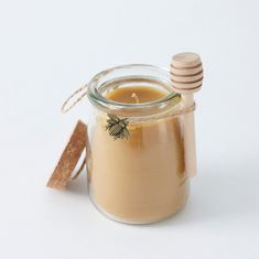 a glass jar filled with liquid next to a wooden stick