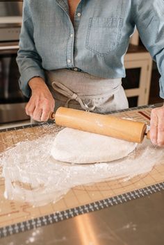 a woman rolling dough on top of a counter