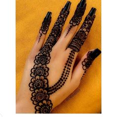 a woman's hand with henna tattoos on it and black nail polishes