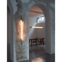 an archway leading to a dining room with a table and chairs in the background,