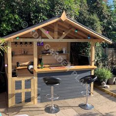 an outdoor bar with two stools in the foreground