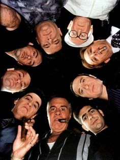 a group of men standing in a circle holding their hands together and making funny faces