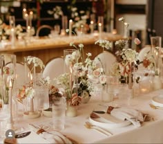 the table is set with flowers and candles