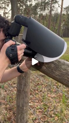 a young man holding a camera up to his face and aiming it at the viewer