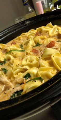 a casserole dish with chicken, spinach and cheese in it on the stove