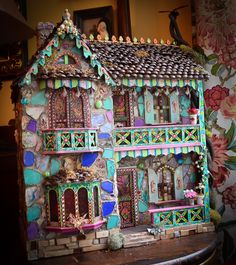 a doll house is made out of clay and decorated with colorful decorations on the outside