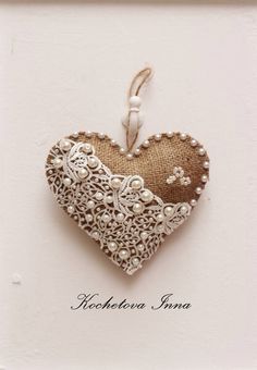 a heart shaped brooch hanging from a string on a white background with the words valentine's day written below it