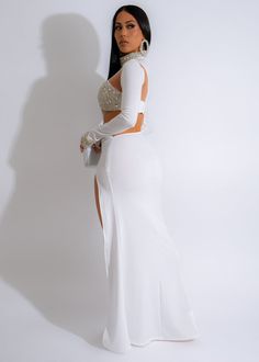 a woman in a white dress posing for the camera with her hands on her hips