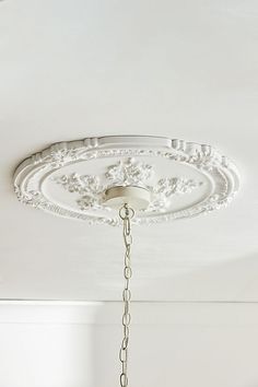 a chandelier hanging from the ceiling in a room with white walls and ceilings