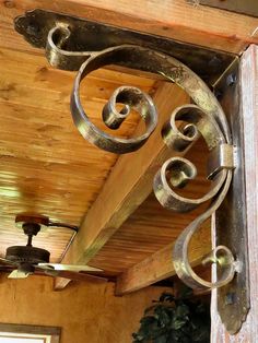 an old fashioned ceiling fan hanging from the side of a wooden building with metal accents