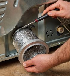 a man is working on an appliance with a wrench in his hand