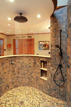 a bathroom with a walk in shower next to a tiled counter top and brown tile walls